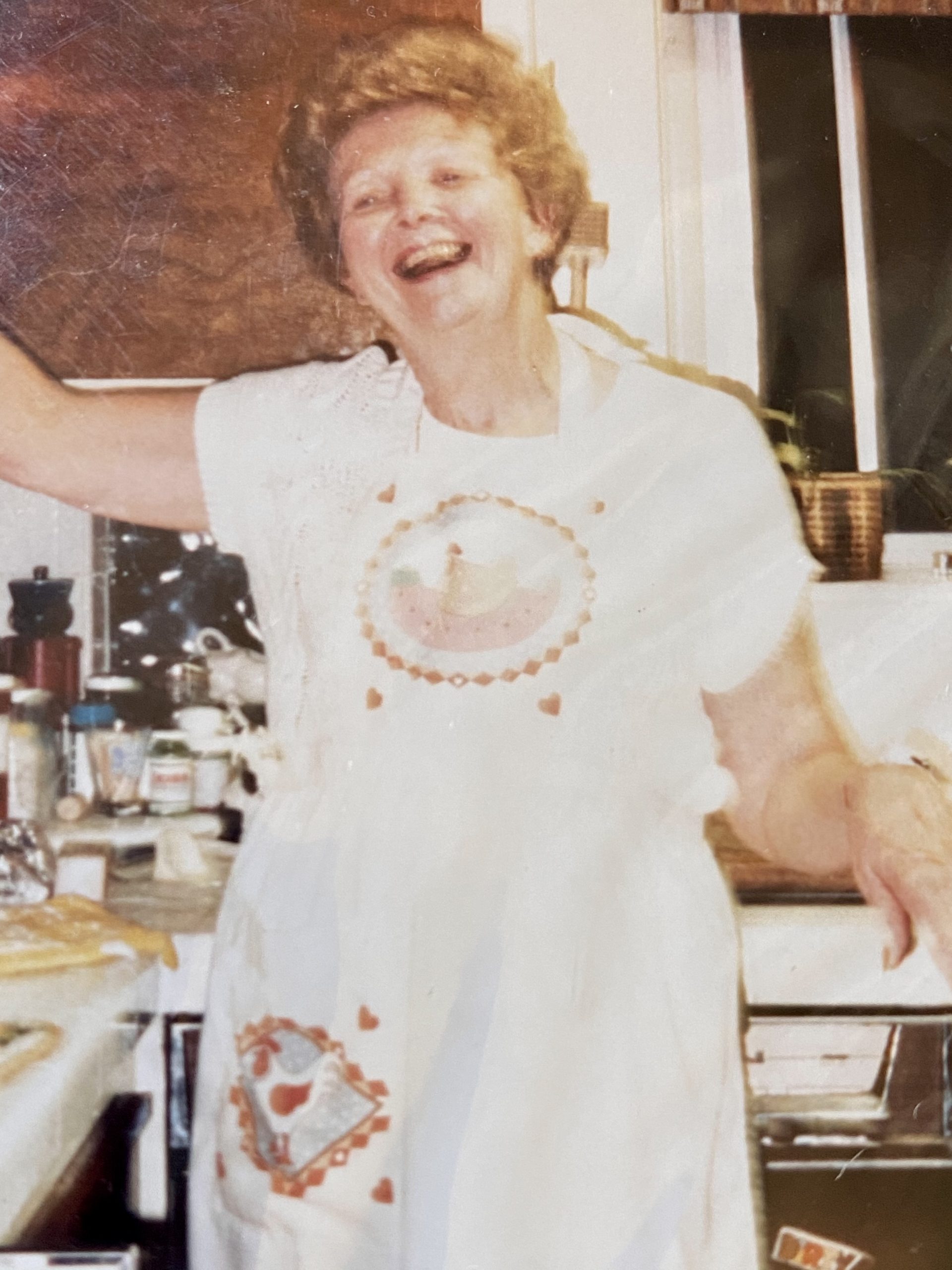 Pam's mother smiling in the kitchen.